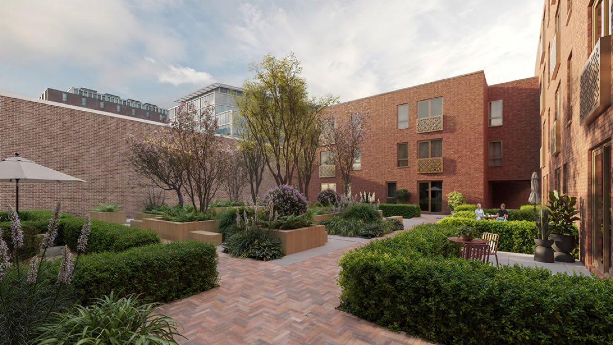 A red brick courtyard building of three and four storeys at Paper Yard on Loveday Street, with planted beds, mature trees and a herringbone brick path between them